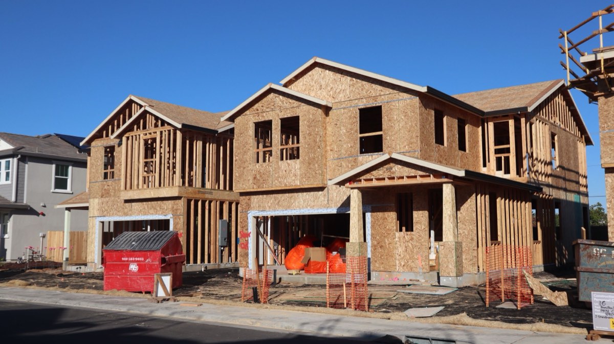 A row of new homes under construction, timber-framed